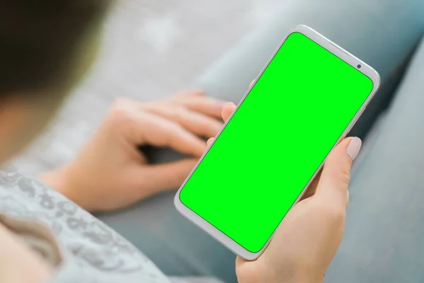 Изображение. Женские руки держат смартфон с зеленым экраном. хрома-ключ. close up . — стоковое фото