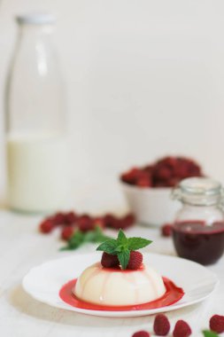 Yaz tatlı. Ahududu ile panakota. Dikey vurdu. Yakın çekim. Açık renkli.
