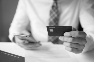 Genç işadamı onun elinde banka kredi kartıyla. Online Döviz Alım Satım ticaret. Malların online ödeme. Online ödeme telefon aracılığıyla. Akıllı telefon ve Internet ticaret.