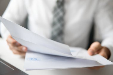 İşadamı'de ofis işleri tabloda belgelerle çalışmak. Mali belgeler iş. Yakın çekim. Bir dizüstü bilgisayar ile ofis işleri. Açık renkli. Smartphone el genç işadamı sakallı.
