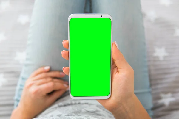 chroma key Green screen smartphone top view Mockup image of woman\'s hands holding mobile phone.