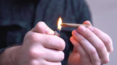 Esrar ortak çakmağı ile kapatın. ışık yalıyor tonda renkli ışık esrar esrar künt haddeleme adam sızdırıyor. Adam bir esrar otu künt haddeleme.