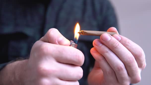 Cierra el porro de marihuana con mechero. luz lame color tonificado luz fugas hombre rodando marihuana cannabis romo. Hombre rodando una marihuana sin filo . — Vídeos de Stock