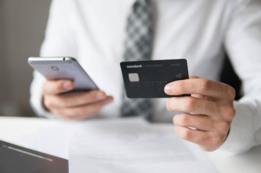 Online Döviz Alım Satım ticaret. Akıllı telefon ve Internet ticareti. Online ödeme telefon aracılığıyla. Genç işadamı onun elinde banka kredi kartıyla. Malların online ödeme.