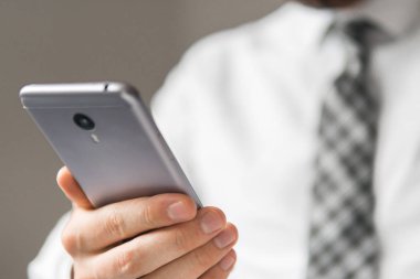 Mali iş. Açık renkli. Bir dizüstü bilgisayar ile ofis işleri. Akıllı telefon elinde tutuyor. İş adamı iş bilgisayar ile ofis işleri tablo. Genç işadamı sakallı.