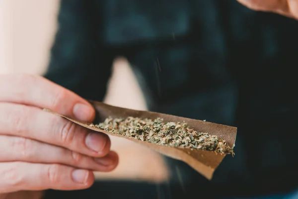 Člověče, přípravu a postupné konopí marihuana Blunt. Omamné léky koncept. Zblízka narkoman rozsvícení marihuany Blunt s lehčí. Zblízka. Muž postupných marihuany užívání drog tupý. — Stock fotografie