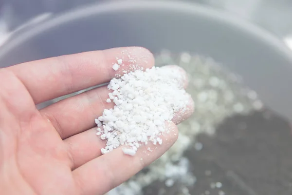 Perlite in the hands of a man. Substrate for marijuana. Close up. Soil growing cannabis. A mixture of earth, perlite and vermiculite. The concept of growing medical cannabis in the doore indoor. — Stock Photo, Image