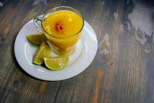 Стакан апельсинового сока и лайма на тарелке — стоковое фото