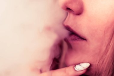 Esrar, elinde esrar Bir kadın sigara içiyor. Siyah arka planda sigara içmek. Tıbbi marihuana kullanımı ve esrar kullanımının yasallaştırılması kavramları. Siyah arka planda Pembe renklendirme