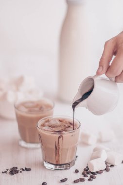 Marshmelow ve kahve fasulye masanın üzerinde. Yaz içeceği. Soğuk kahve süt ve çikolata. Açık renkli. Buzlu kahve. Soğutma içki kavramı.