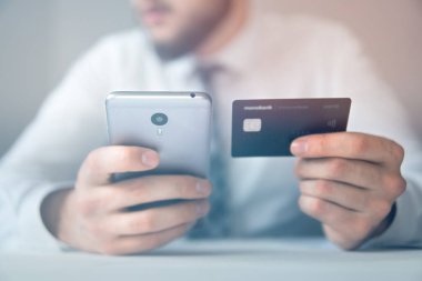 Açık renkli. Bir dizüstü bilgisayar ile ofis işleri. Mali iş. Yakın çekim. Smartphone el genç işadamı sakallı. Bilgisayarda ofis işleri tabloda ile işadamı çalışma.