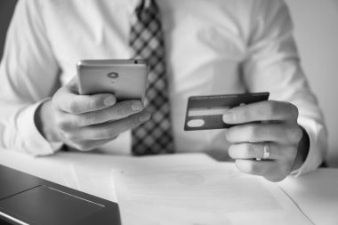 Office iş kavramı. Siyah ve beyaz. E-posta, cep telefonu göndererek belgeleriyle çalışma iş adamı. Beyaz arka plan. İşadamı bir akıllı telefon kullanır.