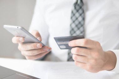 İşadamı bir smartphone ve kredi kartı online ödeme için kullanır. Online alışveriş. Telefonu kapatın. Office iş kavramı. Beyaz arka plan. . Gönderen e-posta, cep telefonu.