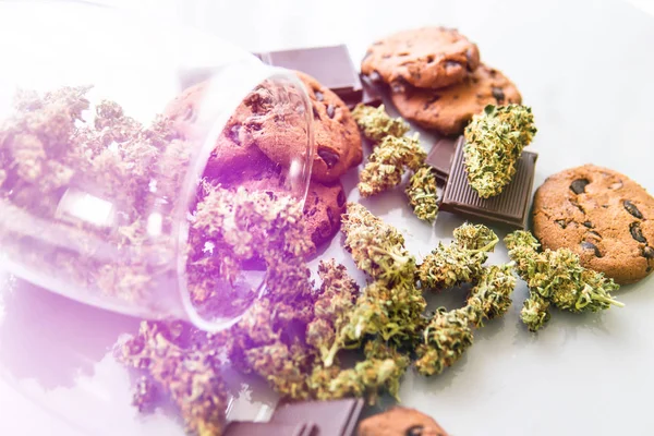 Behandling av medicinsk marijuana för användning i mat, vit bakgrund. Cookies med cannabis ört CBD. Cookies med cannabis och marijuana-knoppar på bordet. lätta läckor — Stockfoto