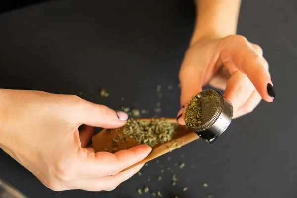 Close-up van marihuana bot met Grinder. Vrouw die een marihuanaverbinding rolt. Marihuanagebruik concept. Vrouw voorbereiding en Rolling marihuana cannabis joint. — Stockfoto