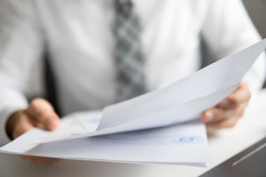 Mali iş. İşadamı ofis işleri ile bilgisayar ofis işleri tablo. Bir dizüstü bilgisayar ile çalışır. Genç işadamı sakallı. Açık renkli.