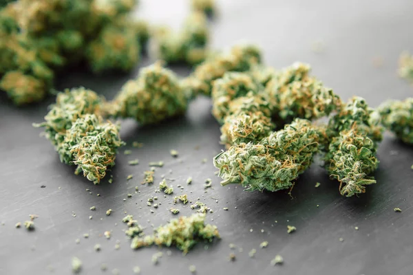 Macro of marijuana bud with trichomes and crushed weed — Stock Photo, Image