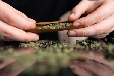 Çakmakla marihuana dükkanını kapat. Esrar saran bir adam. Esrar saran bir adam.