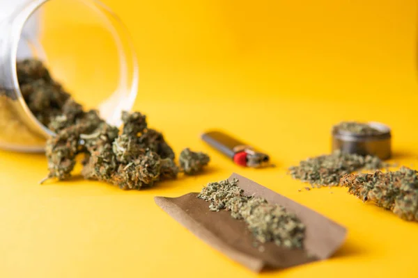 Frisches Marihuana. Stumpf und Feuerzeuge. Cannabis-Knospen auf gelbem Hintergrund für Kopierraum. cbd und thc auf Knospen in Cannabis. Ansicht von oben. Hanf-Legalisierung. — Stockfoto