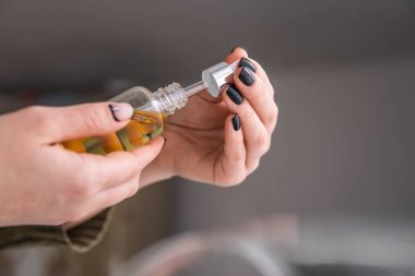 Beyaz arka planda marihuana özütü, tıbbi kenevir konsepti, ot ürünü, yakın plan, pipette kadınların elinde petrol keneviri CBD,