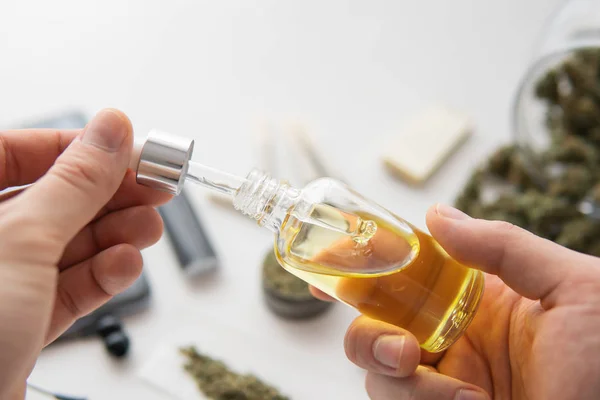 Fles olie Cannabis in pipet in de hand, medisch marihuana concept, close-up, hennepproduct, CBD cannabis olie op witte achtergrond, — Stockfoto