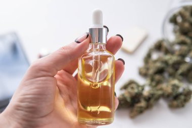Petrol esrarı kadınların elinde CBD, beyaz arka planda marihuana özü, tıbbi kenevir konsepti, kapanış, ot ürünü,