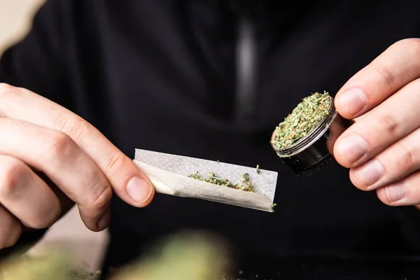 Çakmakla marihuana dükkanını kapat. Esrar saran bir adam. Esrar saran bir adam..