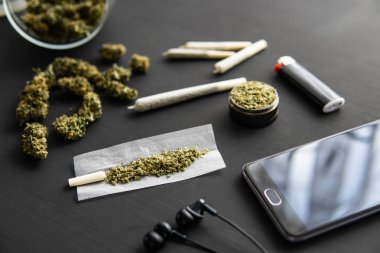 Esrarlı esrar, siyah masada marihuana tomurcukları, yakın plan, elinde taze esrarla öğütücü,