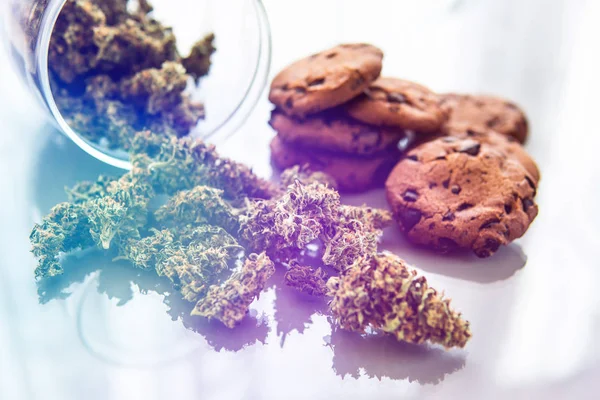 Cookies with cannabis herb CBD. Treatment of medical marijuana for use in food, white background. Cookies with cannabis and buds of marijuana on the table. — Stock Photo, Image