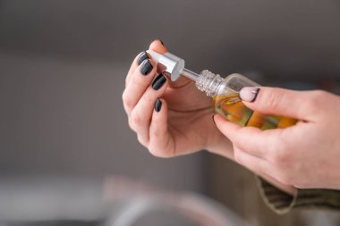 Petrol esrarı kadınların elinde CBD, beyaz arka planda marihuana özü, tıbbi kenevir konsepti, ot ürünü, kapat,