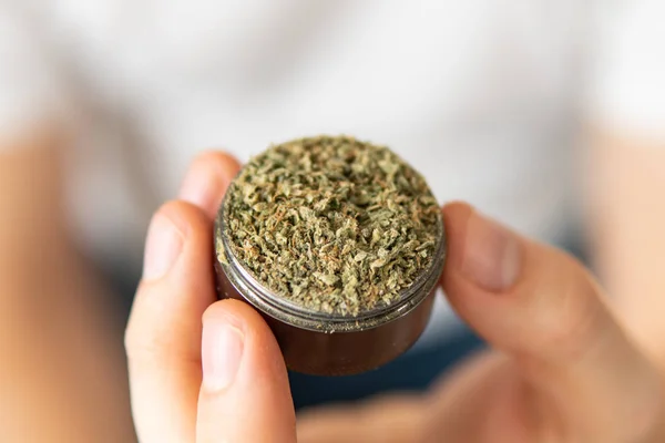 Close up of marijuana GRINDER cannabis use concept. Homem preparando e rolando maconha maconha conjunta. Homem rolando um charro de cannabis no fundo branco . — Fotografia de Stock