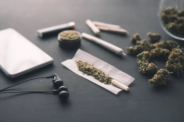 Staw z ziołem, pąki marihuany na czarnym stole, zbliżenie, szlifierka w dłoni ze świeżą marihuaną, — Zdjęcie stockowe
