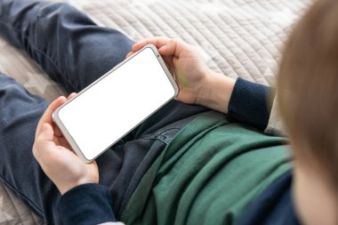 Model için telefon et, çocuğu tutuyor. Akıllı telefon, elinde bir çocuğun maketi var. Elinde beyaz perde olan akıllı bir telefon, çocuk. Üst görünüm kapat