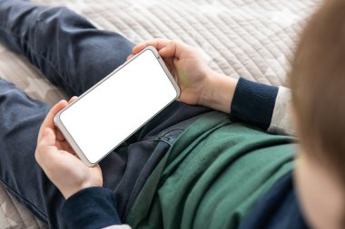 Akıllı telefon, elinde bir çocuğun maketi var. Elinde beyaz perde olan akıllı bir telefon, çocuk. Model için telefon et, çocuğu tutuyor. Üst görünüm kapat