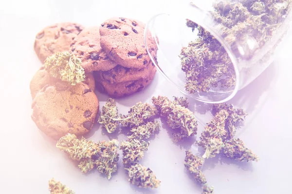 Kannabiszos sütik CBD-vel. Kannabiszos sütik és marihuána rügyek az asztalon. Orvosi marihuána kezelése élelmiszerekben, fehér háttér. — Stock Fotó