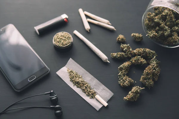 Csiszoló kéz a kézben friss Cannabis, közelről, marihuána bimbók a fekete asztalon, ízületi fű, — Stock Fotó