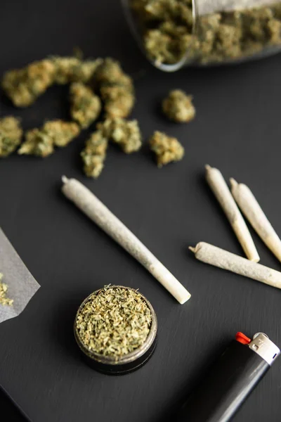 Cannabisknoppen op zwarte tafel, molen in de hand met verse marihuana, close-up, verbinding met wiet, verticaal schot — Stockfoto