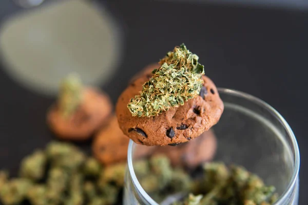 Cookies med cannabis och marijuana-knoppar på bordet. Begreppet matlagning med cannabis ört CBD. Behandling av medicinsk marijuana för användning i livsmedel, svart bakgrund. — Stockfoto