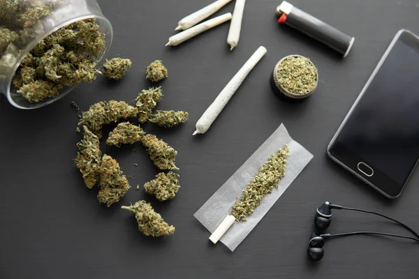 Kvarn i hand med färsk marijuana, närbild, joint med gräs, Cannabis knoppar på svart bord, — Stockfoto