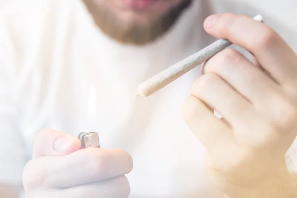 Recreational use of cannabis. Man smoking weed indoor. Smoking marijuana at home. Close up . — Stock Photo, Image