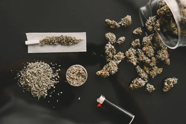 Cannabisknoppen in de hand op zwarte achtergrond Achtergrond voor Kopieerruimte. CBD en THC op toppen in cannabis. Kruidenmolen Verse marihuana. Sluit maar af. Stomp en aanstekers. — Stockfoto