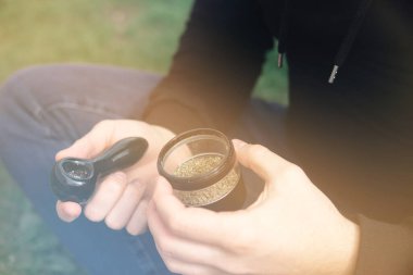 Sativa THC CBD. Kenevir doğa tomurcuğu elimizde. Esrar tomurcuğu ve öğütücü. Doğal arkaplan.
