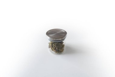 Şeker saksısı tomurcuklara yapışıyor. Marihuana doğası. Beyaz arka plan. CBD THC şifalı bitkisi. Sativa tıbbi sağlığı. Cam kavanozda esrar tomurcukları. Ot toplama zamanı. Marihuana tomurcuklarını buduyorlar.