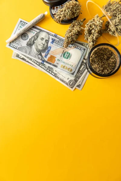 Marijuana weed bud and grinder. Indica medical health. Marijuana bud and banknotes of dollars. Money weed. Cannabis in Economics. Joint weed. Sativa THC CBD. Vertical shot .