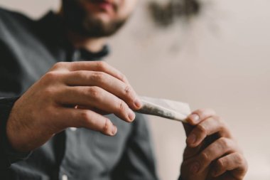 Marihuana esrar mekanı. Esrar sarmak. Esrar kullanımı kavramı. Hazırlanıyor ve yuvarlanıyor Marihuanayı öğütücüyle kapatın.