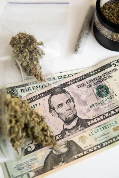 Marijuana bud and banknotes of dollars. Money weed. CBD THC herb. The pot buds. Cannabis in Economics. Cannabis money black market. White background. Sativa medical health. Vertical shot .