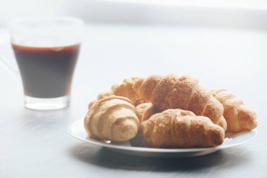 Kahve fincanı ve ahşap arka planda taze pişmiş kruvasan. Üst Görünüm.