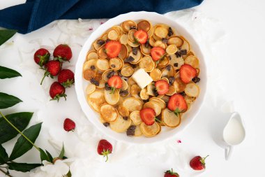 Kışın kahvaltı, klasik tarzda. Bir yığın Amerikan gözlemesi ya da çilekli börek ve yaban mersinli reçel ahşap kırsal masa süslemeli Noel ağacı, lezzetli bir tatlı