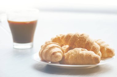 Kahve fincanı ve ahşap arka planda taze pişmiş kruvasan. Üst Görünüm.