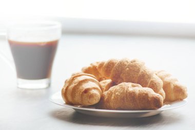 Kahve fincanı ve ahşap arka planda taze pişmiş kruvasan. Üst Görünüm.